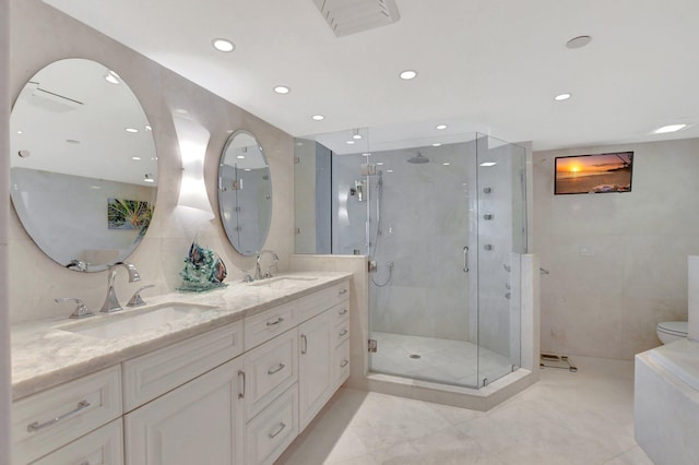 bathroom with toilet, vanity, and a shower with door