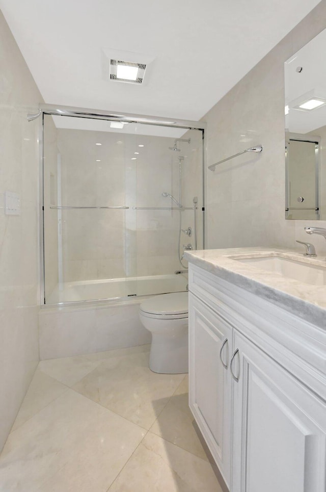 full bathroom featuring toilet, vanity, tiled shower / bath combo, and tile patterned flooring