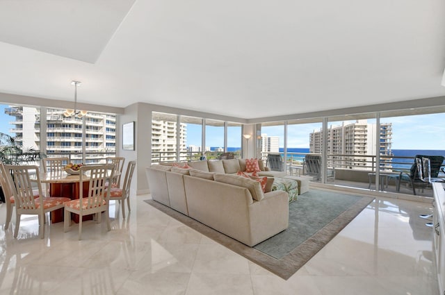 living room featuring a water view, a wall of windows, and light tile patterned floors