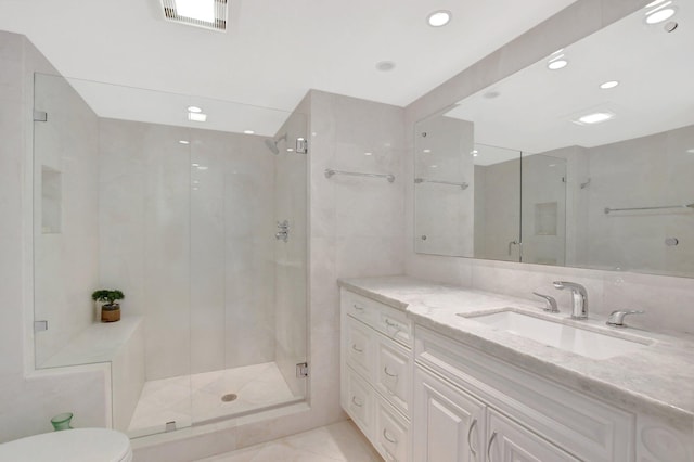 bathroom featuring toilet, tile walls, a shower with shower door, and vanity