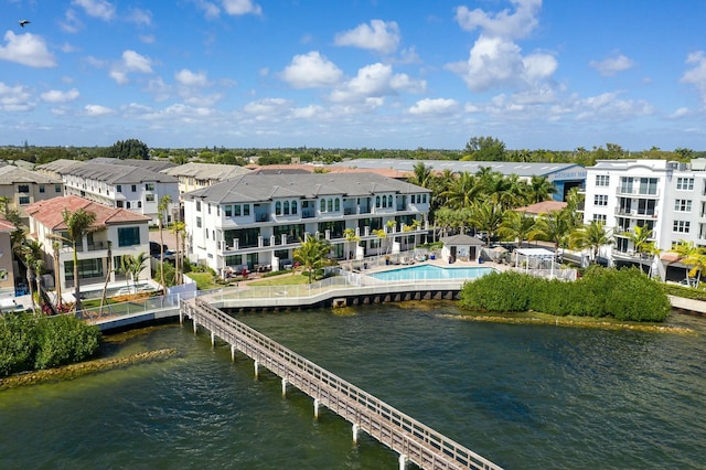 view of dock with a water view, a residential view, and a community pool