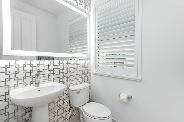 bathroom with backsplash and toilet