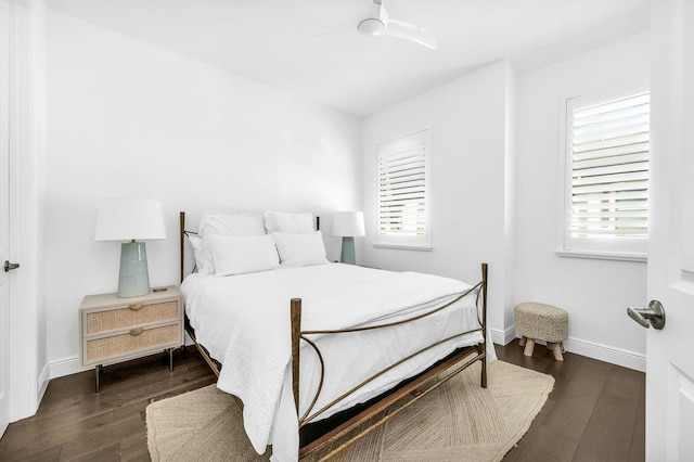 bedroom with ceiling fan, multiple windows, and dark hardwood / wood-style flooring