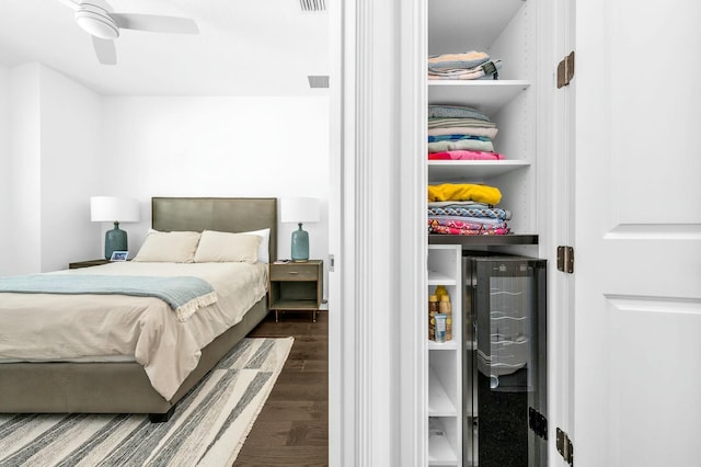 bedroom with ceiling fan, dark hardwood / wood-style flooring, and beverage cooler