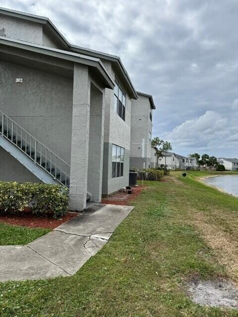 view of property exterior with a yard and central AC unit