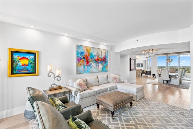 living room with an inviting chandelier and light hardwood / wood-style flooring