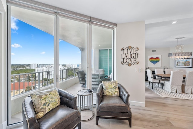 living area with expansive windows and light hardwood / wood-style floors