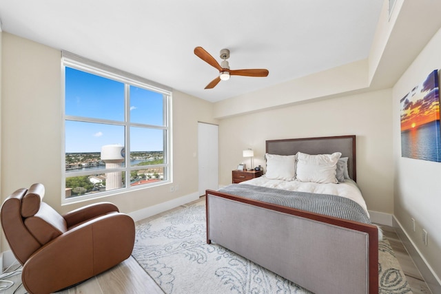 bedroom featuring ceiling fan, light hardwood / wood-style floors, and a closet