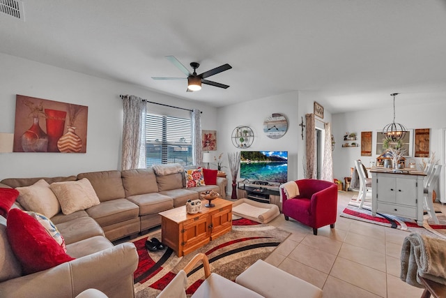 living room with ceiling fan with notable chandelier and light tile patterned floors