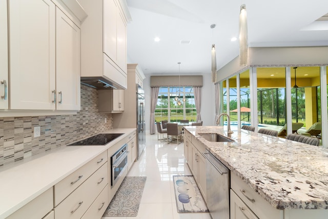 kitchen with sink, decorative light fixtures, light tile patterned floors, decorative backsplash, and stainless steel appliances