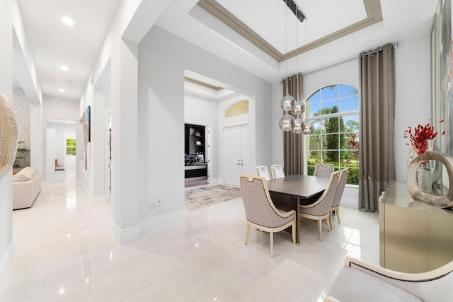 dining space featuring an inviting chandelier, a wealth of natural light, and a raised ceiling