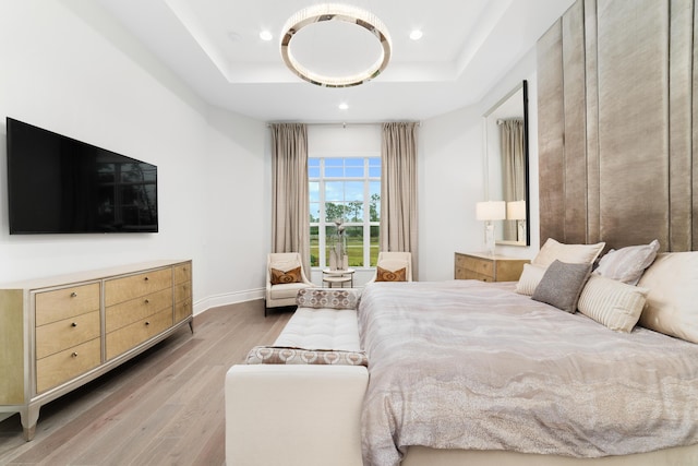 bedroom featuring hardwood / wood-style flooring and a tray ceiling