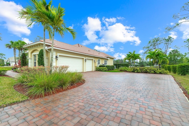 10176 Calabrese Trl, Jupiter, FL 33478 - view of side of home featuring a garage, decorative driveway, stucco siding, and a tile roof