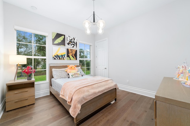 bedroom with wood-type flooring, multiple windows, and a notable chandelier