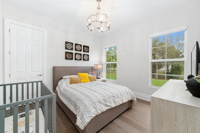 bedroom with wood-type flooring and a chandelier