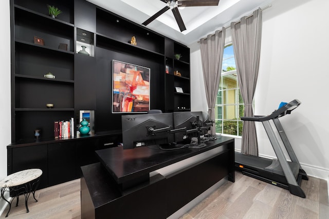 office with ceiling fan, built in shelves, and light wood-type flooring