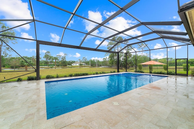 view of pool with a patio area, a lawn, and a lanai