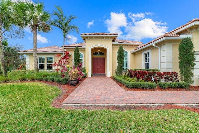 mediterranean / spanish home featuring a front lawn