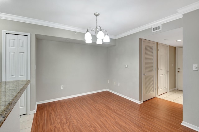 15155 Michelangelo Blvd Unit 201, Delray Beach, FL 33446 - unfurnished dining area featuring light wood-type flooring, baseboards, visible vents, an inviting chandelier, and crown molding