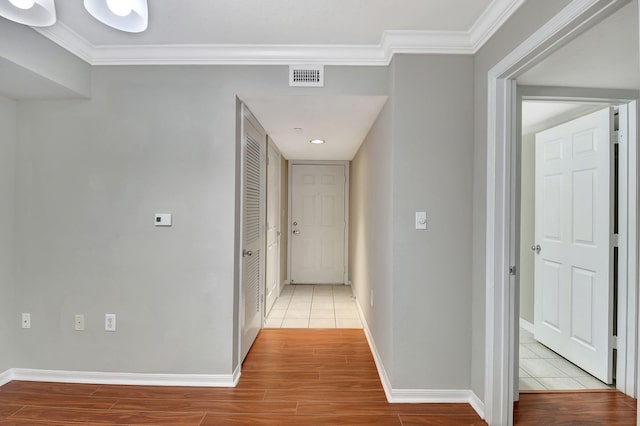 hall with ornamental molding and light wood-type flooring