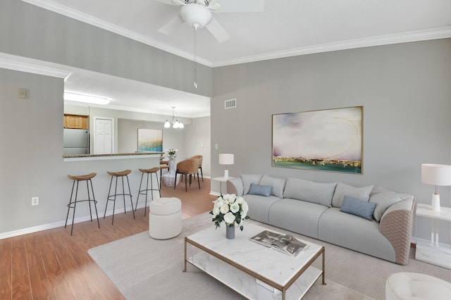 15155 Michelangelo Blvd Unit 201, Delray Beach, FL 33446 - living room with baseboards, light wood-type flooring, ornamental molding, visible vents, and ceiling fan with notable chandelier