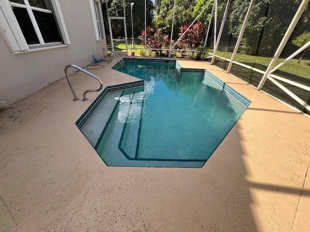 view of pool with a lanai and a patio