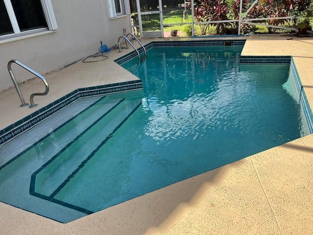 view of pool with a lanai and a patio