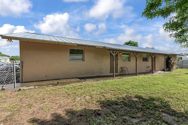 rear view of property with a lawn