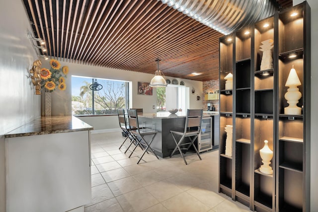 unfurnished dining area featuring wine cooler and light tile patterned flooring