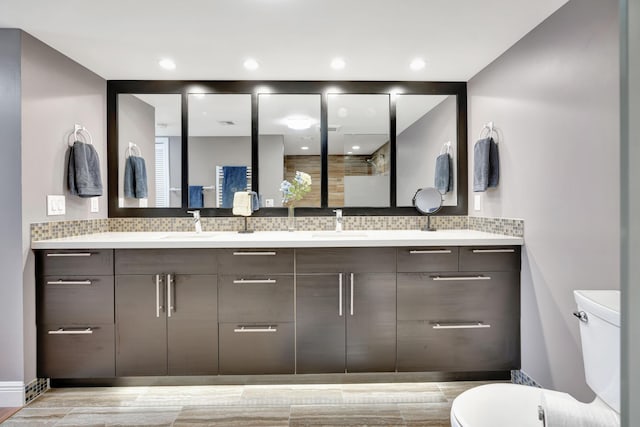 bathroom with tasteful backsplash, vanity, and toilet