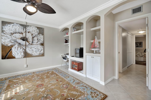 interior space with a textured ceiling, built in features, crown molding, and light tile patterned flooring