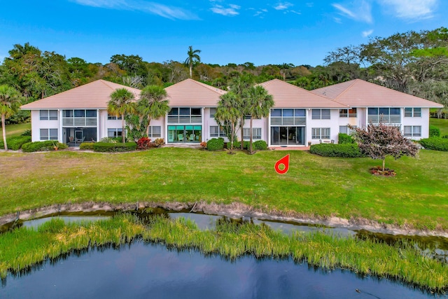 view of front of home featuring a front lawn and a water view