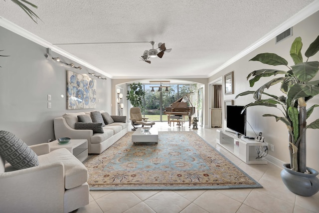 tiled living room with ceiling fan, a textured ceiling, and ornamental molding