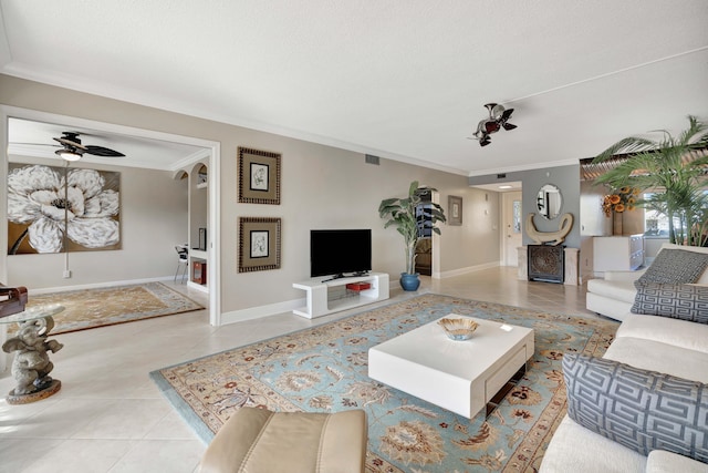 living room with ceiling fan, tile patterned flooring, and ornamental molding