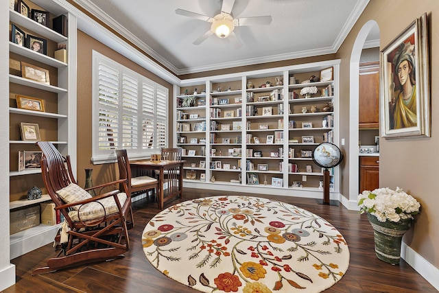 living area featuring ornamental molding, dark wood-type flooring, and ceiling fan