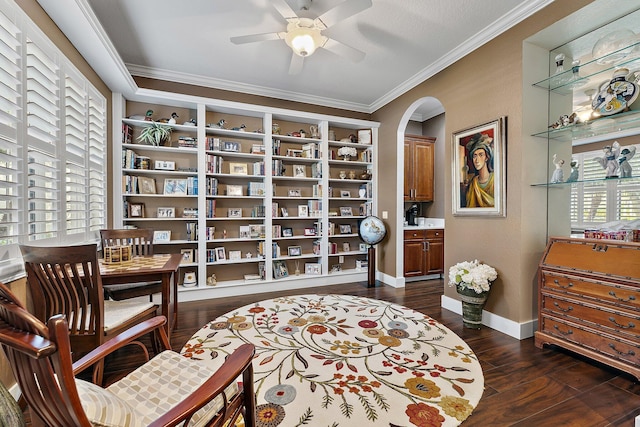 living area with crown molding, dark hardwood / wood-style floors, and ceiling fan