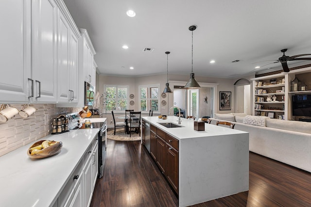 kitchen featuring white cabinetry, appliances with stainless steel finishes, a kitchen island with sink, and sink