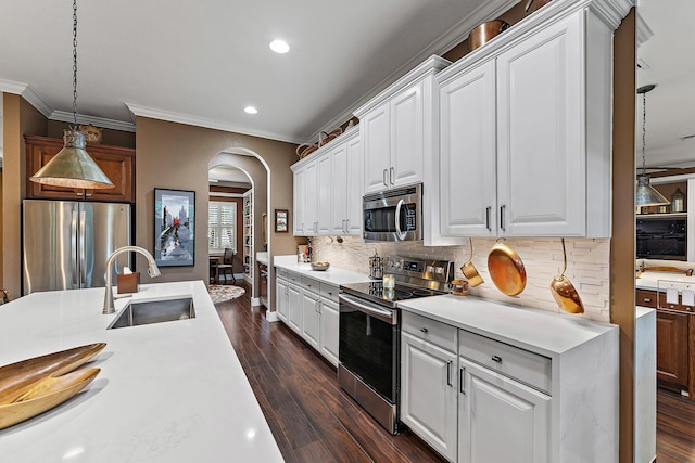 kitchen featuring sink, white cabinetry, tasteful backsplash, appliances with stainless steel finishes, and pendant lighting