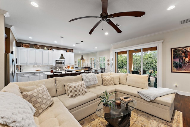 living room featuring light hardwood / wood-style floors, ceiling fan, and ornamental molding