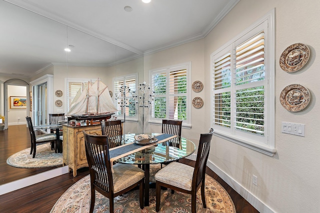 dining space featuring dark wood-type flooring and crown molding