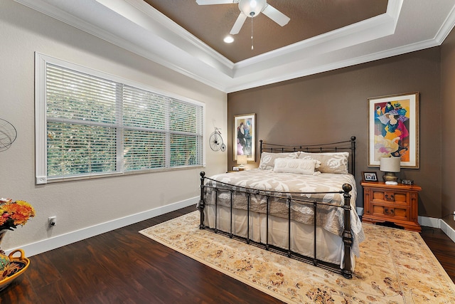 bedroom with ornamental molding, a raised ceiling, ceiling fan, and dark hardwood / wood-style floors