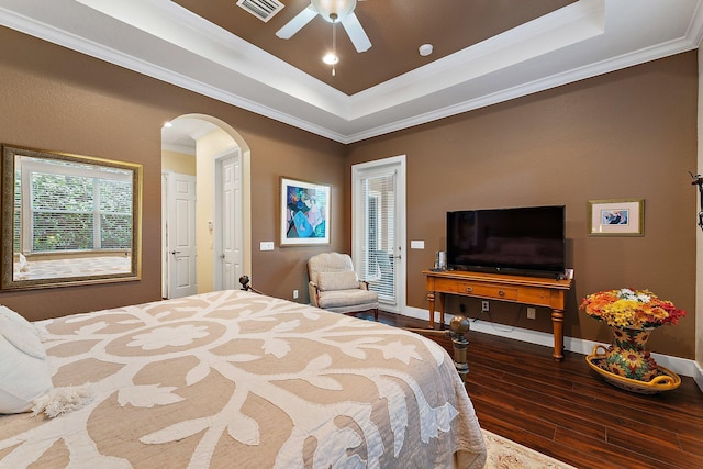 bedroom with ceiling fan, ornamental molding, a raised ceiling, and wood-type flooring