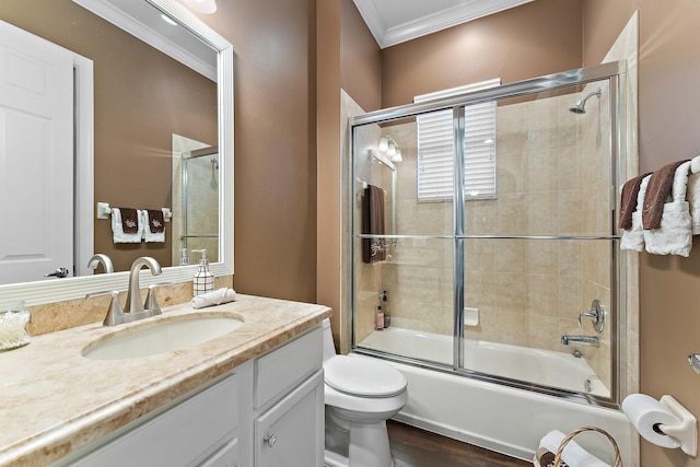 full bathroom featuring shower / bath combination with glass door, ornamental molding, toilet, wood-type flooring, and vanity