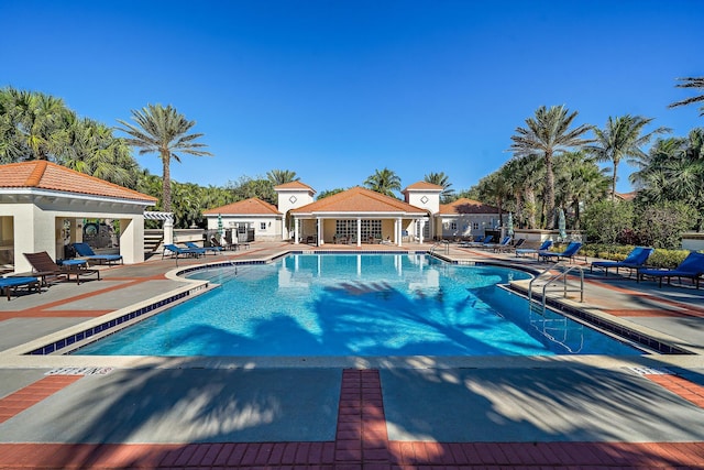 view of swimming pool featuring an outbuilding and a patio area