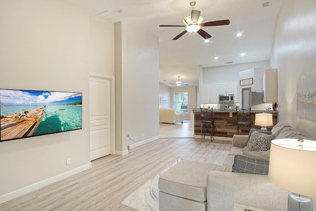 living room featuring light wood-type flooring and ceiling fan