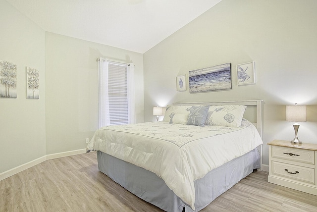 bedroom with light wood-type flooring and vaulted ceiling