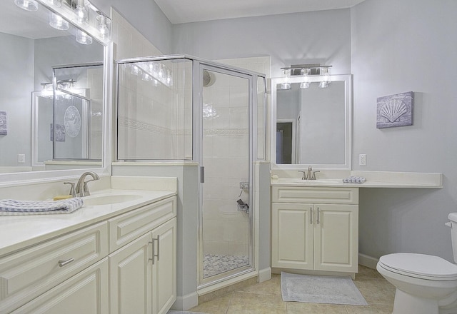 bathroom featuring tile patterned floors, a shower with door, toilet, and vanity