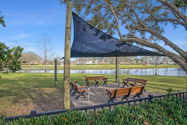 view of home's community with a water view and a lawn