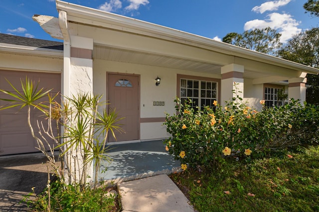 entrance to property featuring a porch and a garage