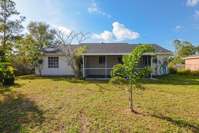 rear view of property with a sunroom and a lawn